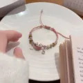 Pink braided lucky cat bracelet detail view with ceramic charm and beads for gifts. - Pink Series