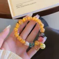 Detailed shot of colorful glass bead bracelet with Pixiu charm for women, retro ethnic style. - Orange Yellow Series