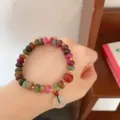 Detailed close-up of a colorful gemstone wheel bead bracelet with jade pendant and gold spacers. - 4 Safety Buckle