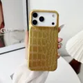 Vista detallada de la lujosa funda para teléfono con textura de cocodrilo dorada. - iPhone17 / Dorado