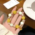 Detailed view of the glass floral bead bracelet featuring yellow and green beads. - Matcha Green Porcelain Bead and Yellow Flower Ball Style