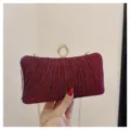 Sparkly wine red evening clutch bag detail, showing pleated texture and elegant ring clasp. - Red
