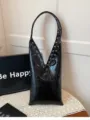 Black glossy patent leather shoulder underarm bag with metal eyelets and lace-up design. - Black