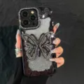 Close-up detail of luxury bling rhinestone butterfly phone case with sparkling glitter gradient design. - Black With Glitter Paper / iPhone 17