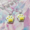 Close-up detail shot of cute resin cat paw dangle earrings, sweet dopamine style jewelry. - Yellow and White Cat Paw Style (A24-257R)
