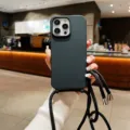 Close-up van de matte beschermende telefoonhoes met een verstelbare zwarte draagriem. - iPhone16promax / Zwart