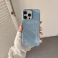 Vista detallada de la funda de teléfono con textura de mezclilla azul y buen agarre. - iPhone 15 / Azul Medio