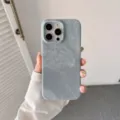 Vista detallada de una funda para telefono con textura de tela, elegante y protectora. - iPhone 15 / Azul claro