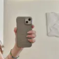Vista detallada de la funda de teléfono con textura de cocodrilo gris en la mano. - iPhone 12 / Macaron Cocodrilo - Gris