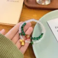Exquisite double-layer agate bracelet with green beads and gold bells, Chinese style. - White & Green Agate Contrast