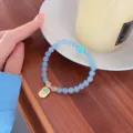 Delicate light blue natural stone beaded bracelet with pendant, sweet style detail view. - Aquamarine with Gold Plated Heart Sutra Pendant