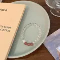 Detailed view of white crystal and pink strawberry crystal beaded bracelet with silver charm. - Three Strawberry Crystals and 925 Silver Cube Style