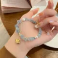 Detail shot of a refreshing blue natural stone chip and pearl bracelet with a cute gold charm. - Gravel Aquamarine with Shell