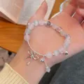 Close-up detail of sweet pink cat eye stone bracelet with cute silver bow pendant jewelry. - 1 Bowknot Style