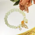 Gros plan détail du bracelet de perles de cristal avec de charmants pendentifs de fleurs. - Nœud / Vert Pâle