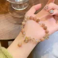 Detailed close-up shot of the handmade crystal gemstone bracelet featuring a cute shell pendant. - Sunstone Shell Pendant Style