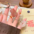 Vue détaillée du collier artisanal de style chinois avec des pendentifs en agate et jade. - Serrure de Sécurité Jade Fleur de Pêcher + Corde Abricot