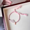 Delicate braided pink crystal bracelet with lucky charm pendant, sweet adjustable design. - Rose Quartz Lying Cat