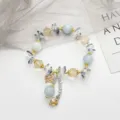 Superbe bracelet de perles en cristal avec des perles bleu clair et champagne et des charmants. - Papillon en Pierre Bleue / Bleu Clair