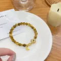 Gold tiger eye stone bracelet with four leaf clover pendant, elegant Chinese style crystal jewelry. - Lucky Flower Style