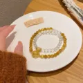 Detail shot of the new Chinese style yellow crystal and golden tiger eye double layer bracelet. - Patterned Disc Double Circle Style