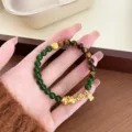 Detailed view of Chinese style natural tiger eye and green stone Pixiu bracelet with charms. - Tiger Eye Jasper Pi Xiu Pendant / Pixiu Style