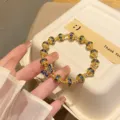 Close-up detail of the vintage gold-plated beaded bracelet with blue enamel butterfly charm. - 1 Blue Beads + Butterfly Beads