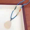 Chinese style natural white agate Buddha pendant necklace with blue braided cord detail. - 3 Haze Blue