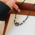 Obsidian cat pendant necklace detail view showing exquisite braided rope and beads. - Cat Head