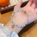Elegant cat eye stone bead bracelet detail showing crystal charm and golden details. - Pave Ball