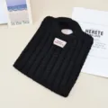 Detailansicht der schwarzen Strickhandtasche mit strukturiertem Zopfmuster und Griff. - Schwarz