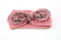 Dettaglio ravvicinato della fascia in maglia rosa con fiocco, rete e ricami di paillettes. - Rosa