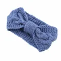 Gedetailleerde close-up van de blauwe gebreide hoofdband met stijlvol kabelpatroon en strik. - Denimblauw