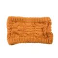 Gros plan sur les détails d'un bandeau tricoté chaud à texture torsadée élastique. - Orange