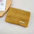 Solid color mustard yellow knitted headband with metal tag, warm and cozy winter hair accessory. - Turmeric