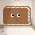 Close-up detail of the cute cartoon sandwich cookie floor mat, featuring soft absorbent surface. - Caramel Sandwich Biscuit Irregular