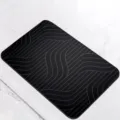 Detail shot of modern black diatomite bath mat with grey wavy lines, fast drying anti-slip. - 40*60cm / Black Curve