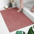 Absorbent bathroom floor mat detail showing soft dusty rose surface and anti-slip backing structure. - Cement Watermelon Red