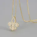 Detailansicht der eleganten goldenen Lilien-Halskette mit funkelnden Zirkoniasteinen. - Gold