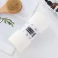 White coral fleece bath towel rolled with paper band, soft absorbent face towel for home daily use. - Off White