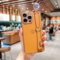 Coque de téléphone galvanisée orange avec lanière de poignet cœur pour iPhone, accessoire pratique. - Cœur Creux Électroplaqué + Dragonne Vide / Brun Lumière Chaude / iPhone 14 Pro Max