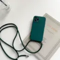 Dark green silicone phone case detail showcasing soft texture and sturdy adjustable lanyard strap. - Midnight Green / iPhone 13