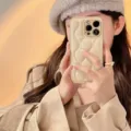 Beige puffer quilted leather phone case detail, stylish winter phone accessory close up. - Curved Brown / iPhone X/XS