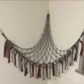 Handmade macrame toy hammock for corner wall storage, grey cotton net with festive ribbons. - Gray
