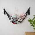 Zwarte macrame speelgoed hangmat, handgeweven boho pop opbergnet voor de muur thuis. - Zwart