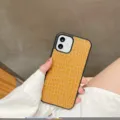 Vista detallada de una funda de teléfono de cuero con motivo de cocodrilo y textura elegante. - iPhone X/XS / Amarillo