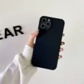 Primer plano detalle de funda de teléfono de silicona negra en mano contra pared blanca. - Negro / iphoneXR