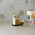 Vue détaillée d'un charmant renard en peluche assis gracieusement sur une surface propre. - Renard Jaune