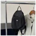 Schwarzer Nylon Mini-Rucksack für Damen, kompakter Freizeitrucksack mit praktischer Vordertasche. - Schwarz