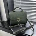 Donkergroene tas met reliëf, vintage schoudertas met handvat en metalen slot. - Groen